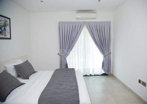 阿克拉Yenko Fie Suites: The Signature Apartments, Accra Ghana的一间卧室设有一张床和一个大窗户