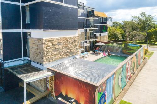罗托鲁瓦Urban Lounge Sleepery的一座带游泳池的建筑,上面有绘画作品