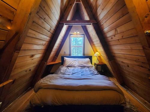 朱诺Douglas Island A-frame Cabin in the Woods的木制阁楼卧室配有一张床