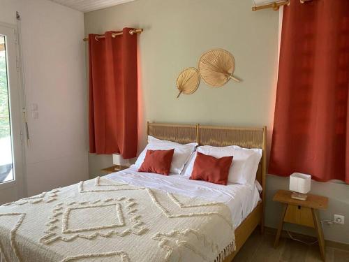 拉特里尼泰Villa Cannelle -charmante et tout confort的一间卧室配有一张带两张红色窗帘的床