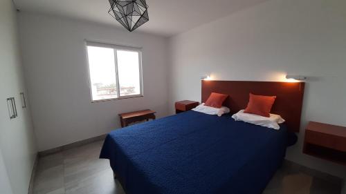 蓬塔内格拉CASA DE PLAYA Todo el año的一间卧室设有蓝色的床和窗户。