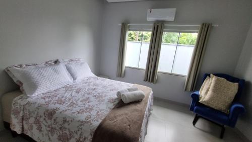 锡诺普Casa Nova com Suíte!的卧室配有床、椅子和窗户。