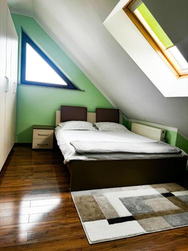 勒德乌齐Adonis Oasis Rădăuți的一间卧室设有一张床和绿色的墙壁