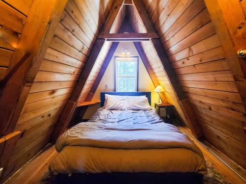 朱诺Cabin & A-Frame w/ Firepit near Fishing & Trails的木制阁楼卧室配有一张床