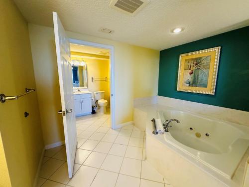 代托纳海滩Club Wyndham Ocean Walk的浴室设有白色浴缸和绿色墙壁。