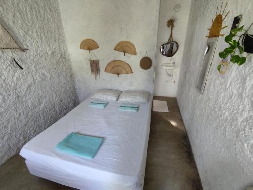 卡诺格布拉达Hostel Flor da Vida的小房间,墙上有一张带遮阳伞的床