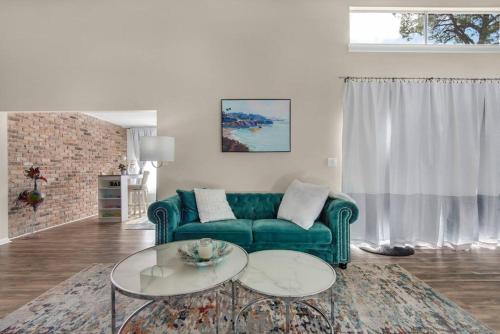 彭萨科拉Quiet Home, Perdido-Orange Bch, Golf View 3BR-2BT的客厅配有绿色沙发和2张桌子