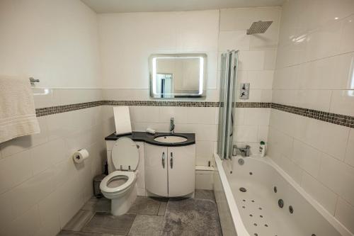 Great BursteadAlaya’s home的浴室配有卫生间、盥洗盆和浴缸。