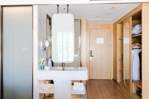 淳安千岛湖假日酒店的浴室设有白色水槽和镜子