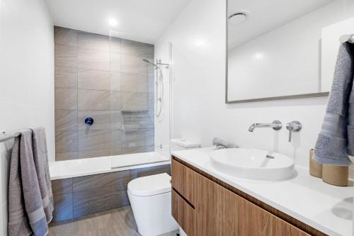 黄金海岸Village Palm Beach - Brand New 2 Bedroom Apartment的白色的浴室设有水槽和卫生间。