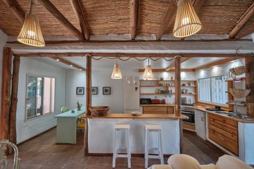 塔里法Bolonia Beach Campus的厨房设有木制天花板和带凳子的台面。