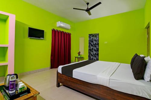 布巴内什瓦尔Khushi Guest House的一间拥有绿色墙壁的卧室和一张位于客房内的床