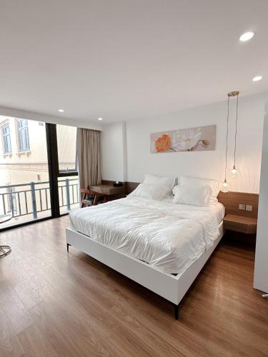 河内TINH ANH HOME的卧室设有白色的床和大窗户