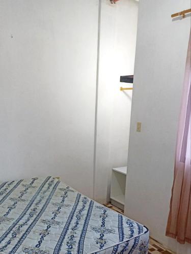 SalinasSuit Salinas/ semiamueblado的一间卧室设有一张床和白色的墙壁