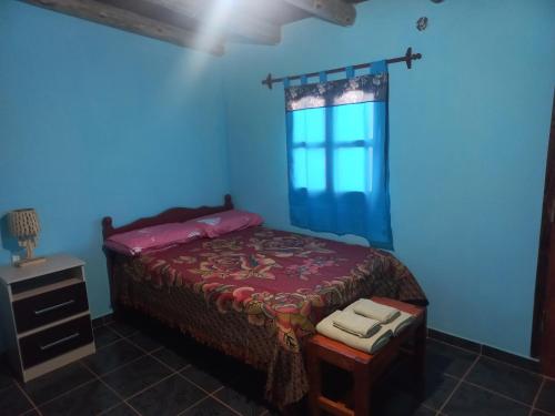卡奇Casa de familia的蓝色的卧室设有床和窗户