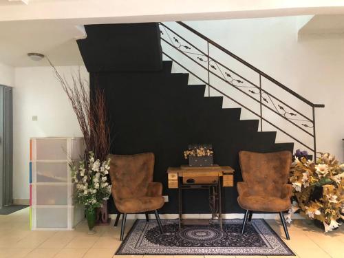 万挠Homestay Country Homes Rawang的客房设有2把椅子、书桌和楼梯。