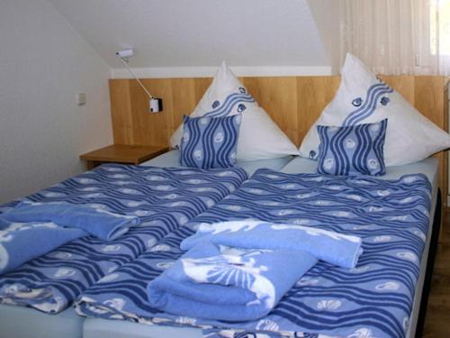 克洛斯特Ferienwohnung auf Hiddensee im Ort Kloster的一张带蓝色和白色床单及枕头的床