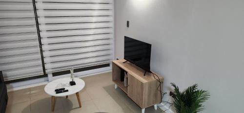 科金博Departamento Coquimbo的客厅配有电视、桌子和壁炉