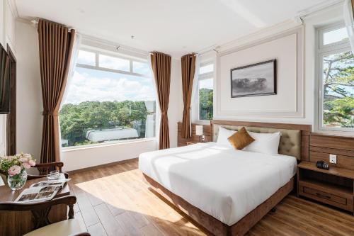 大叻PINE VIEW Hotel Dalat的卧室设有白色的床和大窗户