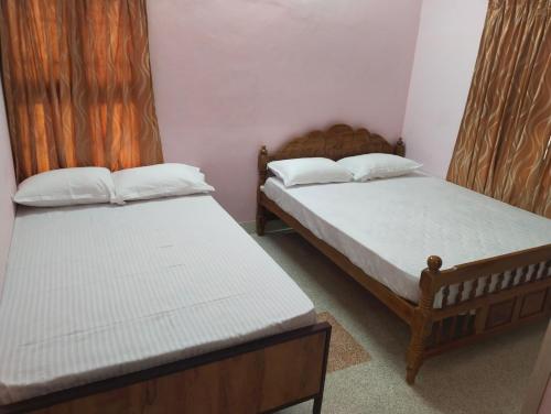 蒂鲁内尔维利Sharada Homestay的配有两张床的小房间,带有ermott