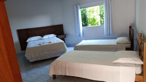 卡塞雷斯Hotel Turazzi的一间卧室设有两张床和窗户。