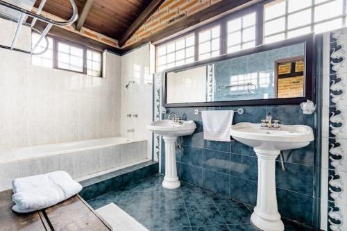 伊瓦拉Quinta María Alfonsina的浴室配有两个盥洗盆和浴缸。
