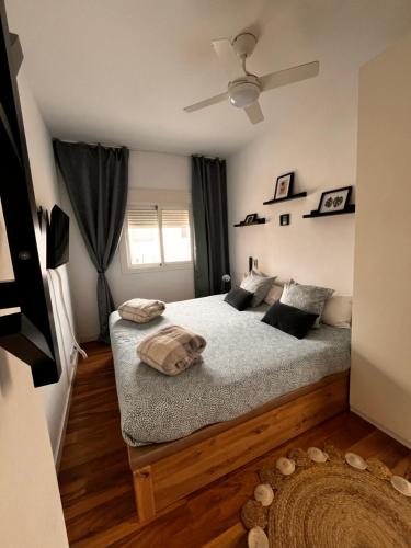 卡尔塔马Apto-Estudio 20 min-centro Málaga的一间卧室配有一张床和吊扇