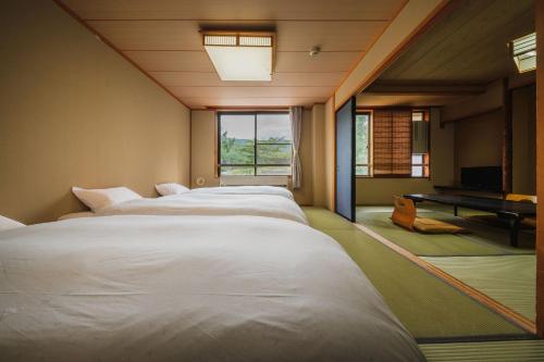 藏王温泉高宫哈蒙德酒店的电视机房间里一排白色的床