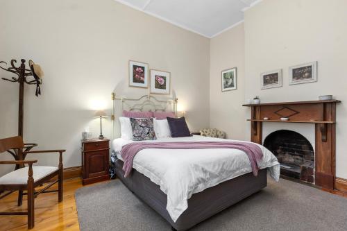 塔南达Miriams Cottage的一间卧室设有一张大床和一个壁炉