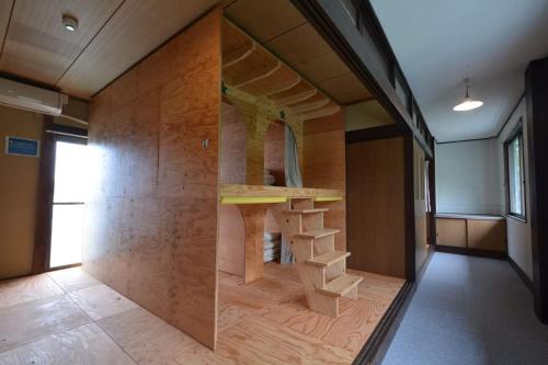 尾道市Guest House Gamigami的一间设有木墙和书架的房间