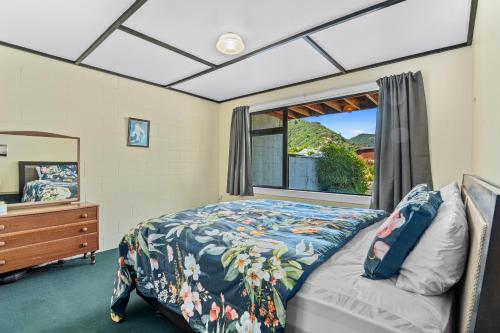 皮克顿Coastal Charm - Picton Holiday Home的一间卧室设有一张床和一个窗口