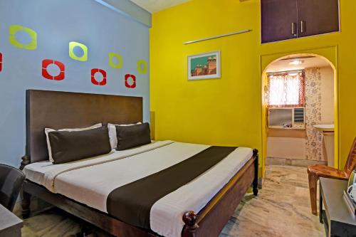 布巴内什瓦尔Chilika Residency的一间卧室配有一张黄色墙壁的床