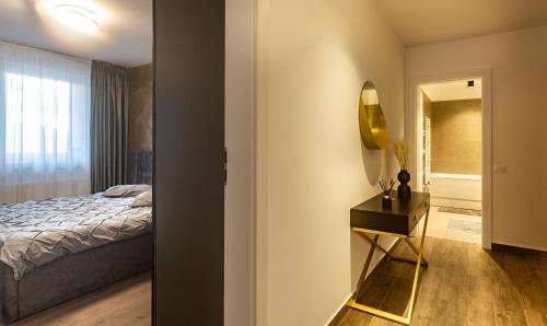 布拉索夫Carpatilor Apart Hotel Brasov的一间卧室配有一张床和一张带镜子的桌子