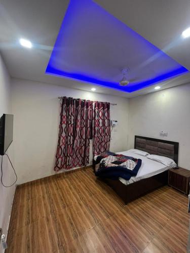 阿姆利则SHRI GANPATI GUEST HOUSE的一间设有床铺和蓝色天花板的客房