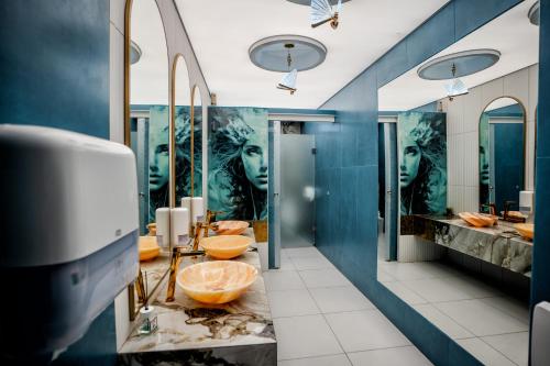 克利默内什蒂Complex Turistic Casa Romaneasca的浴室设有蓝色的墙壁、水槽和镜子