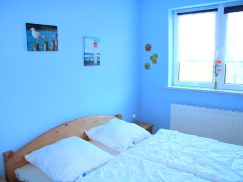 格洛韦Ferienwohnung in Glowe auf Rügen的蓝色卧室 - 带2个枕头和床