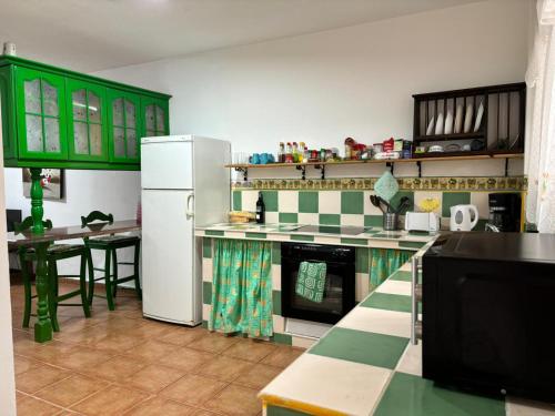 Abadeshabitación en un bajo 2 camas individual casa compartida的厨房配有绿色橱柜和白色冰箱