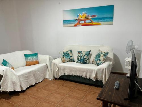 Abadeshabitación en un bajo 2 camas individual casa compartida的客厅配有两把椅子和墙上的绘画