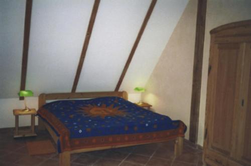 PutgartenFerienwohnung Rügen in Putgarten的一间卧室配有一张带蓝色棉被的床