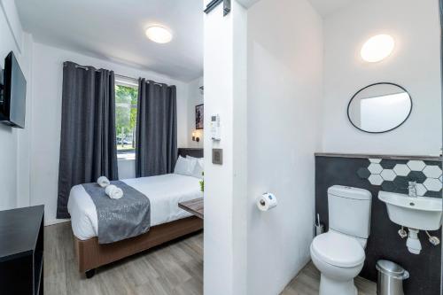 维多利亚瀑布维多利亚瀑布城N1营地酒店的浴室设有床、卫生间和水槽。