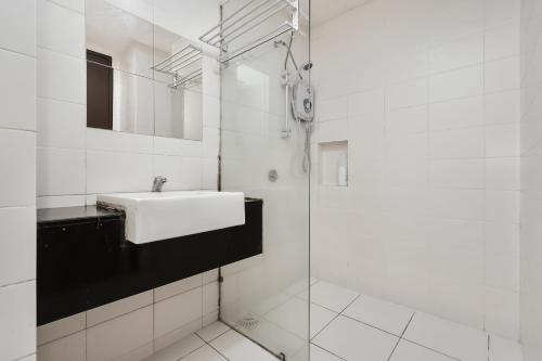 实达阿南The Night Stand - Trefoil Setia Alam的白色的浴室设有水槽和淋浴。