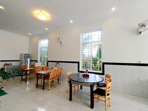 贡布Kampot Coco Guest House的用餐室设有桌椅和窗户。