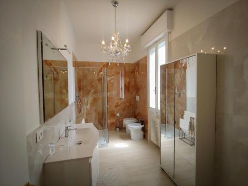 雷诺河畔卡萨莱基奥EDC home con parcheggio e self check in的一间带卫生间、水槽和吊灯的浴室