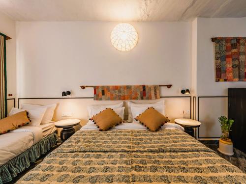 斋浦尔Sum Jaipur的一间卧室配有一张大床和两张桌子