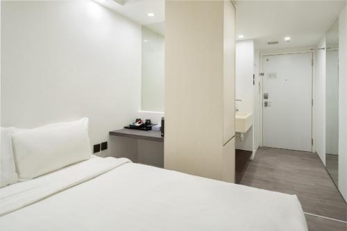 新加坡Lion Peak Dickson的一间白色卧室,配有床和一间浴室