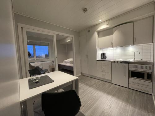 斯沃尔韦尔Vestfjordgata Apartment 12的白色的厨房配有桌椅和一张床