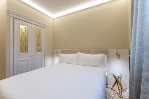 威尼斯San Vio Palace Luxury Apartments的卧室配有白色的床和门