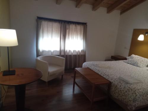 Valdeavellano de Tera维拉巴姆巴酒店的卧室配有床、椅子和窗户。