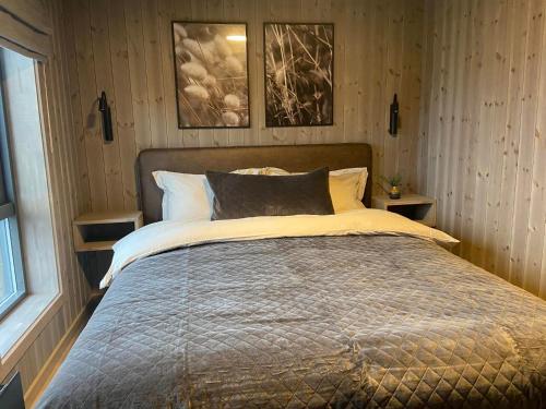 ÅfarnesHjortehytte的卧室内的一张床铺,墙上有两张照片