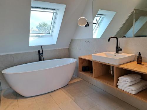 埃肯弗德Eck am Meer 6的浴室配有大型白色浴缸和水槽